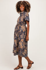 woman wearing a navy blue floral maternity dress with short sleeves and a tie waist, showing her baby bump