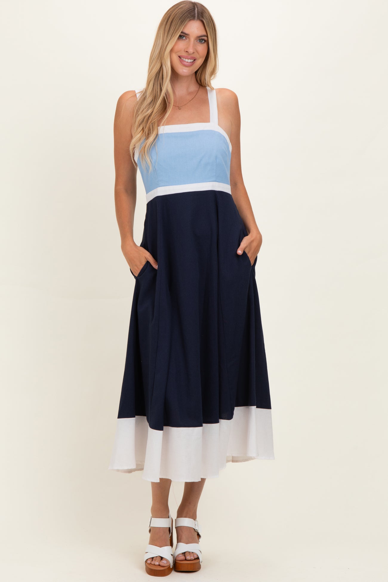 woman wearing a navy blue and light blue color block maxi dress with pockets and wide straps