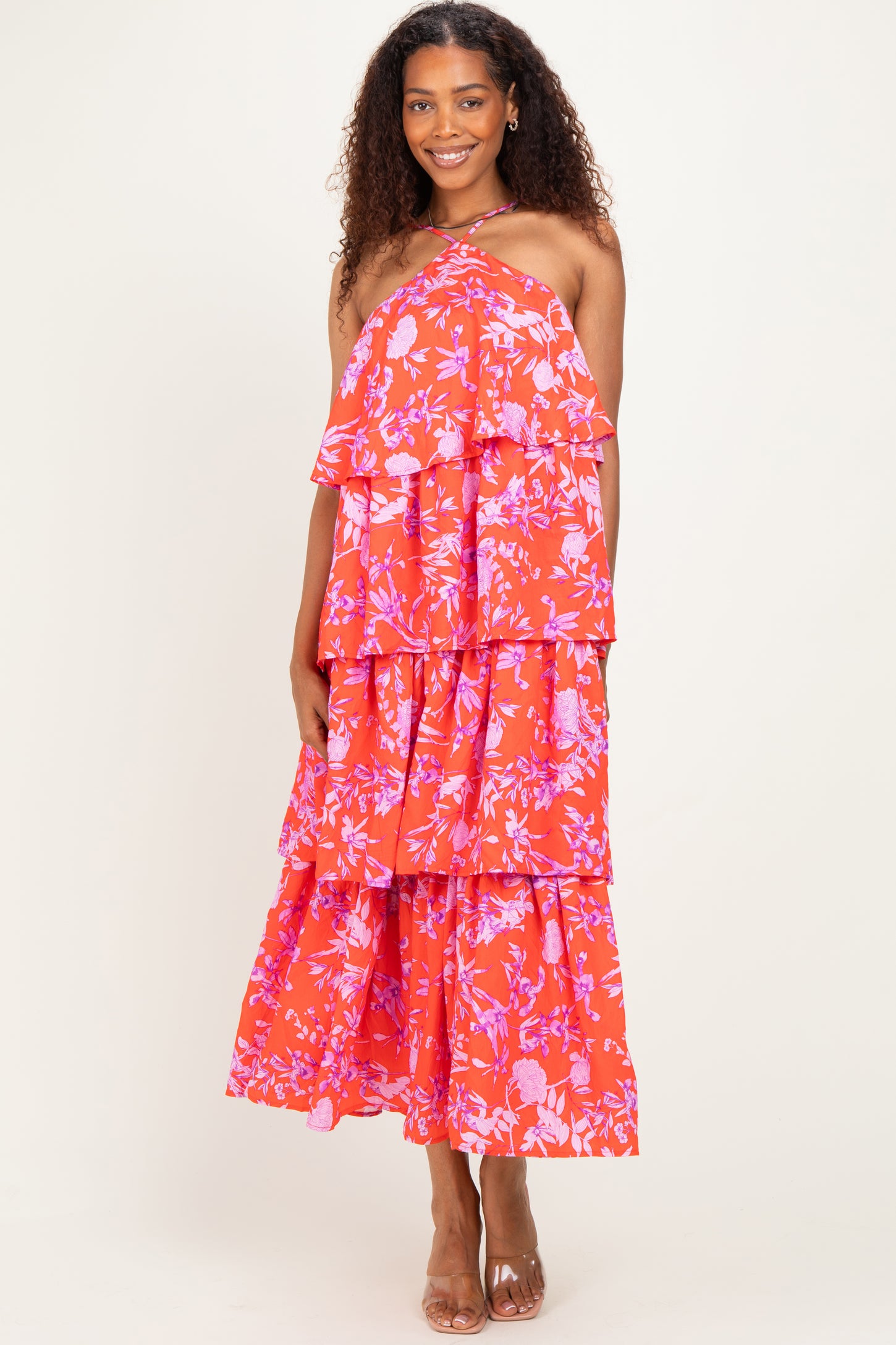 woman wearing a red floral tiered maxi dress with spaghetti straps and a flowy silhouette