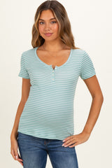 woman wearing a light teal striped maternity top with short sleeves and a henley neckline, showing a baby bump