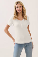 woman wearing a white short sleeve ribbed top with button detail and ruffled hemline