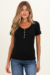 woman wearing a black short sleeve maternity top with ruffle details and button accents in a casual style