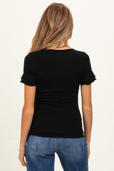 woman wearing a black ribbed maternity top with ruffled short sleeves and a fitted silhouette
