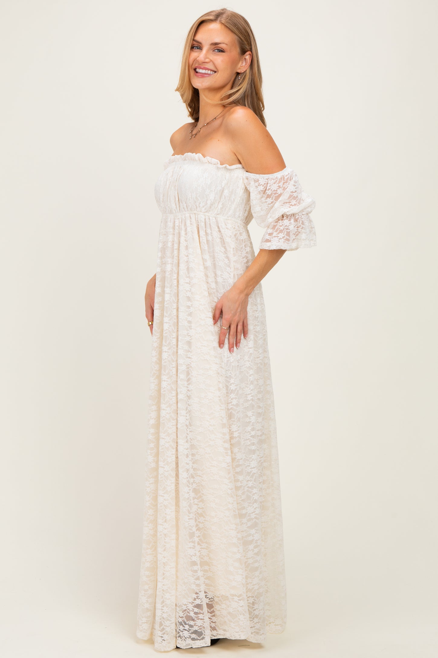 woman wearing a cream off-the-shoulder lace maxi dress with bell sleeves