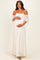woman wearing a white off-the-shoulder lace maternity dress and holding her baby bump