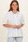 woman wearing a white striped button-up shirt with a relaxed fit and short sleeves