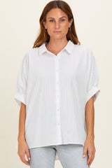 woman wearing a white short sleeve button-up blouse with a relaxed fit and subtle stripe detail