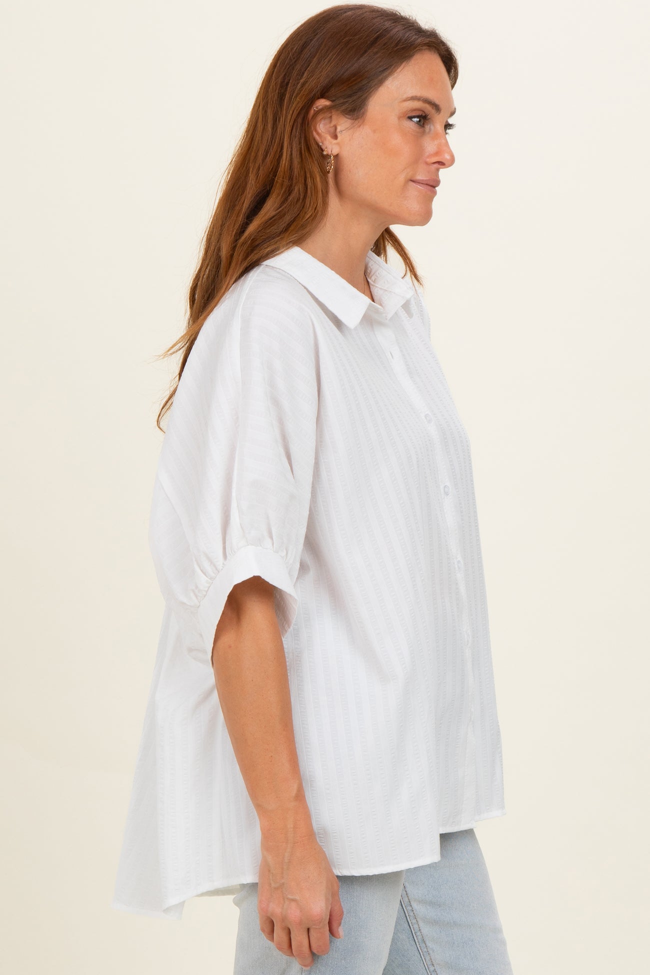 woman wearing a white oversized button-up shirt with short sleeves and a relaxed fit