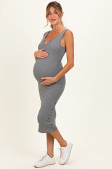 woman wearing a gray ribbed maternity dress with a v-neck and buttons, holding her baby bump