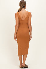 woman wearing a rust ribbed maternity dress with a deep v-back and fitted silhouette