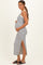 woman wearing a black and white striped maternity dress with a side slit and holding her baby bump
