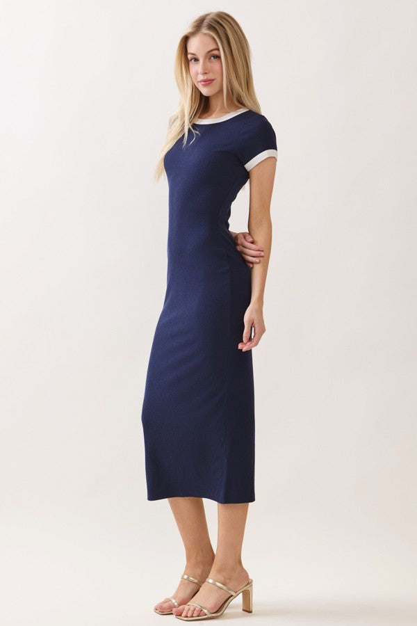 woman wearing a navy blue midi dress with contrasting white sleeves and side slits