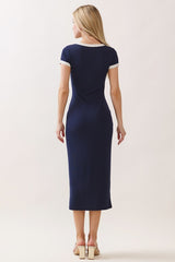 woman wearing a navy blue fitted midi dress with short sleeves and white trim, shown from the back
