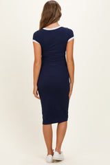 woman wearing a navy blue maternity dress with short sleeves and a form-fitting design, showing a baby bump from the back