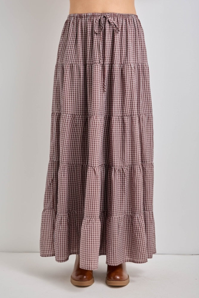 woman wearing a checked tiered maxi skirt with a drawstring waist and brown ankle boots