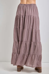 woman wearing a long brown plaid tiered maxi skirt with an elastic waistband and ankle boots