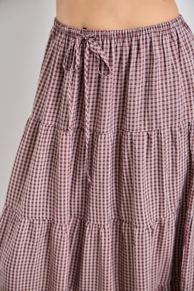 woman wearing a maroon and white checkered tiered maxi skirt with a drawstring waist