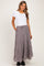 woman wearing a white short sleeve maternity top and a long black and white checked tiered skirt with pockets