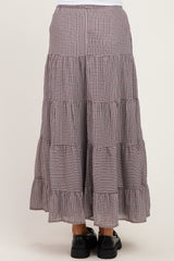 woman wearing a maternity midi skirt with a tiered design in a checkered pattern and a ruffled hem