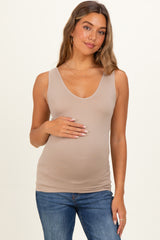 woman wearing a beige maternity tank top and showing her baby bump