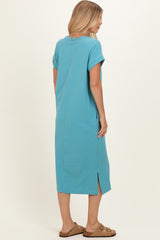 woman wearing a turquoise short sleeve maxi dress with side slits and a relaxed fit, view from the back