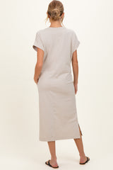 woman wearing a light gray maternity dress with short sleeves and a side slit, viewed from the back