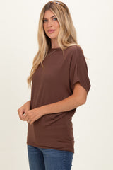 woman wearing a brown short sleeve top with a relaxed fit and smiling