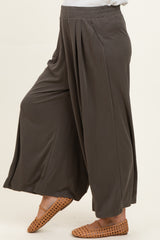 maternity wear wide leg pants in dark gray with pleated detail, paired with tan slip-on shoes.