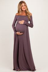 woman wearing a mauve off-the-shoulder maternity gown and holding her baby bump