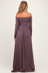 woman wearing a long mauve off-shoulder maternity gown, showing a flowing silhouette from the back