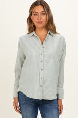 woman wearing a light green and white striped maternity shirt with button details and long sleeves
