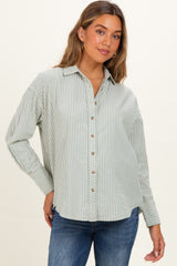 woman wearing a green and white striped maternity button-up shirt with long sleeves and a relaxed fit