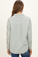 woman wearing a green and white striped maternity button-up shirt, shown from the back