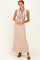 woman wearing a beige ribbed maxi dress with a black tie detail and high neckline, standing on a plain background