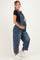 woman wearing a dark blue denim maternity overall, holding her baby bump with a black t-shirt underneath