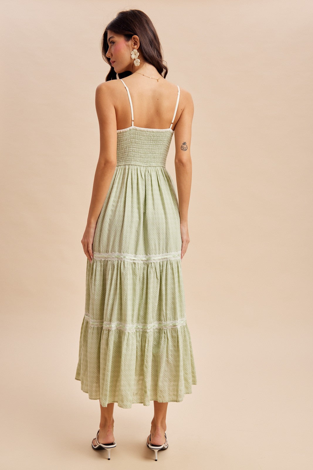 woman wearing a green midi dress with a smocked bodice and tiered skirt, shown from the back