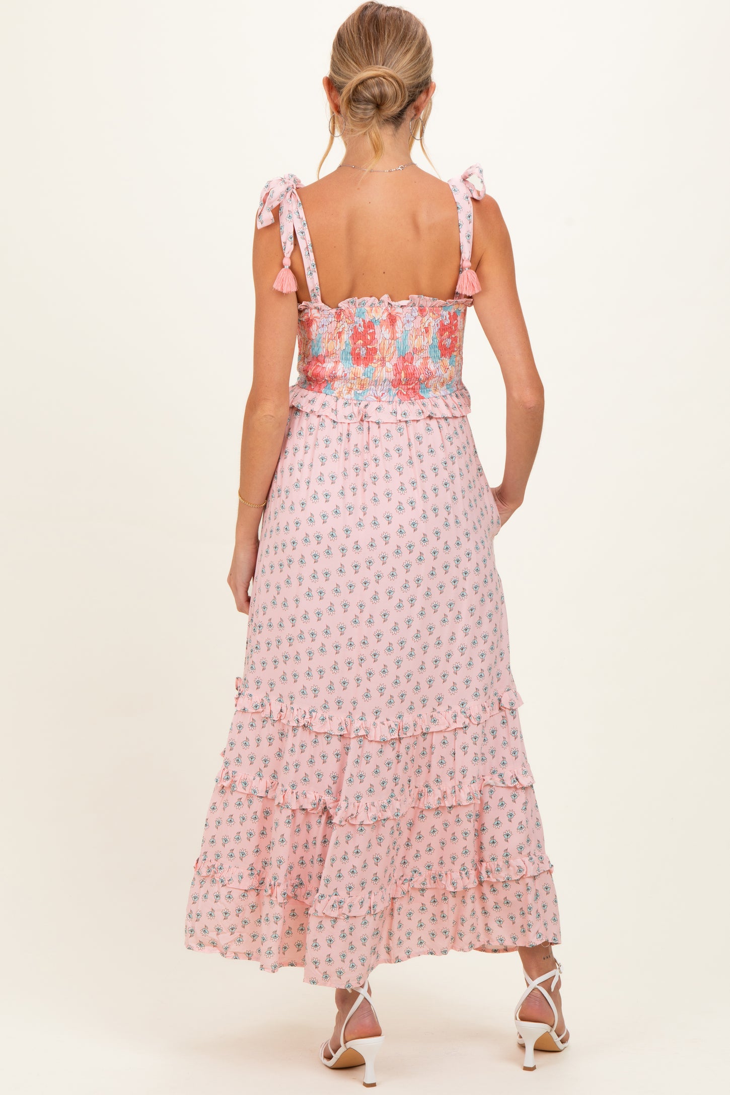 woman wearing a pink floral maternity maxi dress with ruffled tiers and tie straps