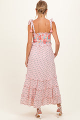 woman wearing a pink floral maternity maxi dress with ruffled tiers and tie straps
