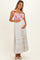 woman wearing a floral maternity maxi dress with tie straps, crisscross bodice, and baby bump visible
