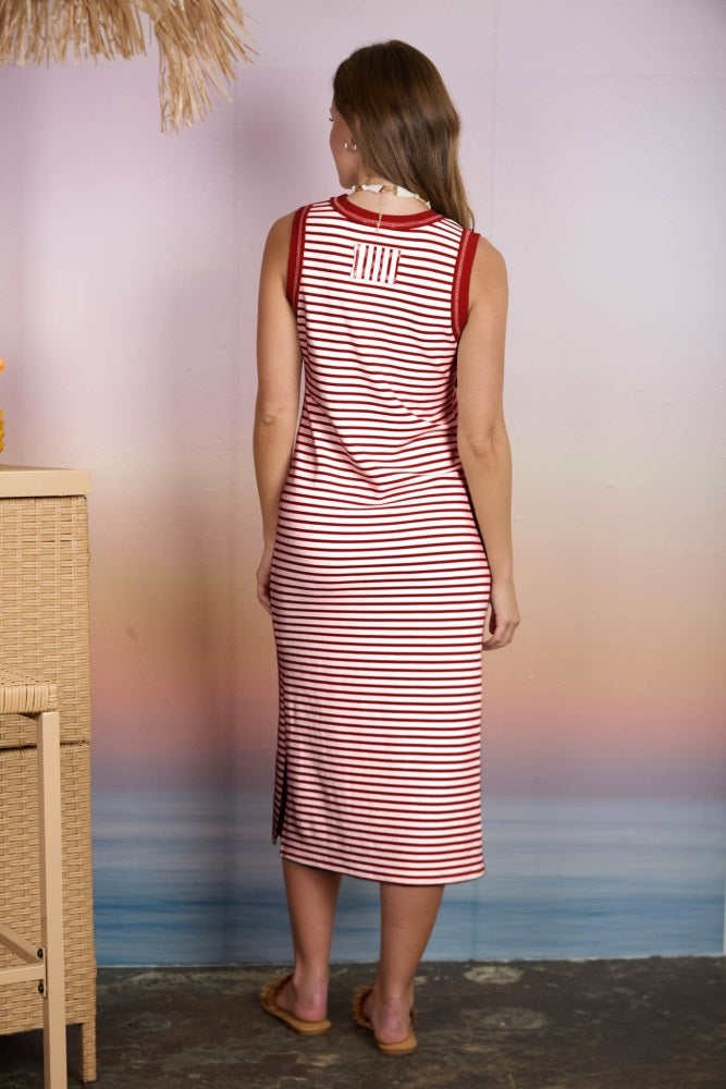 woman wearing a red and white striped maxi dress, viewed from the back, with a side slit and a casual style