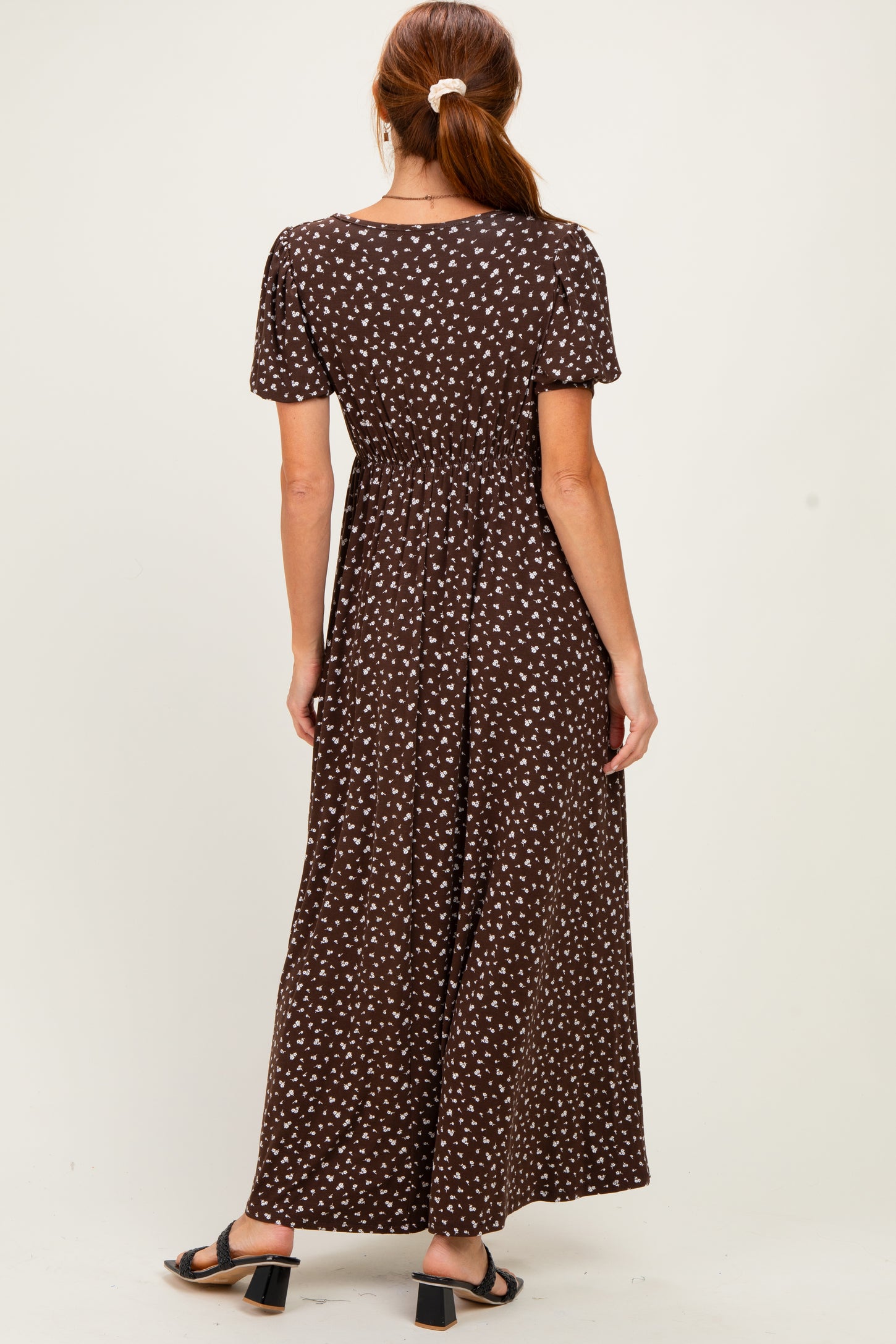 woman wearing a brown maxi dress with white polka dots and short sleeves, showing the back view