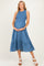 woman wearing a blue maternity dress with smocked bodice and tiered skirt, holding her baby bump