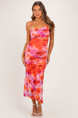 woman wearing a vibrant floral maternity dress with spaghetti straps and a form-fitting silhouette, accentuating her baby bump