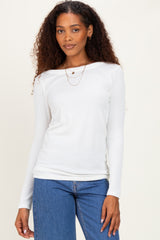 woman wearing a white ribbed long sleeve top paired with blue high-waisted jeans