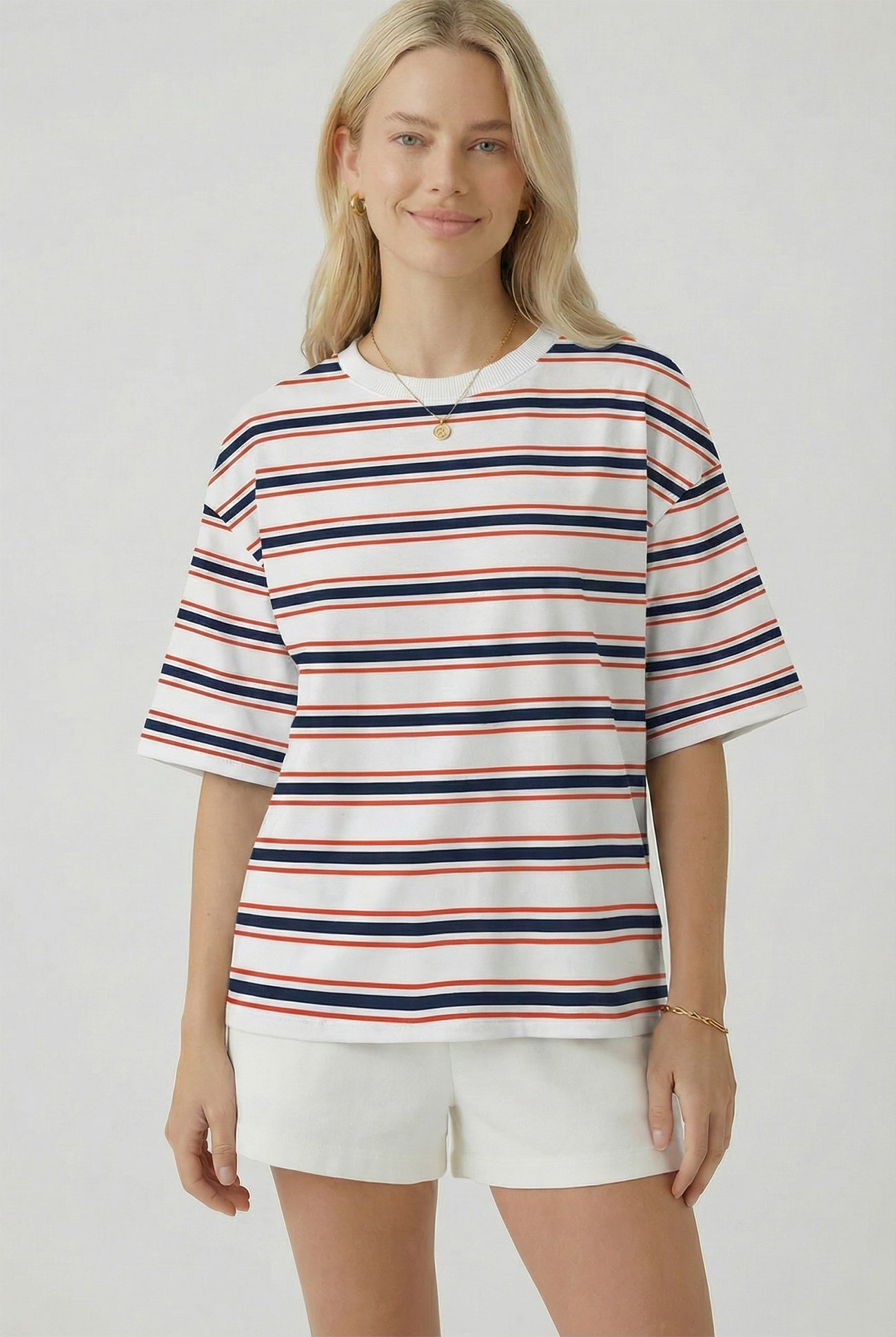woman wearing a white short sleeve striped t-shirt with red, navy, and blue stripes and white shorts