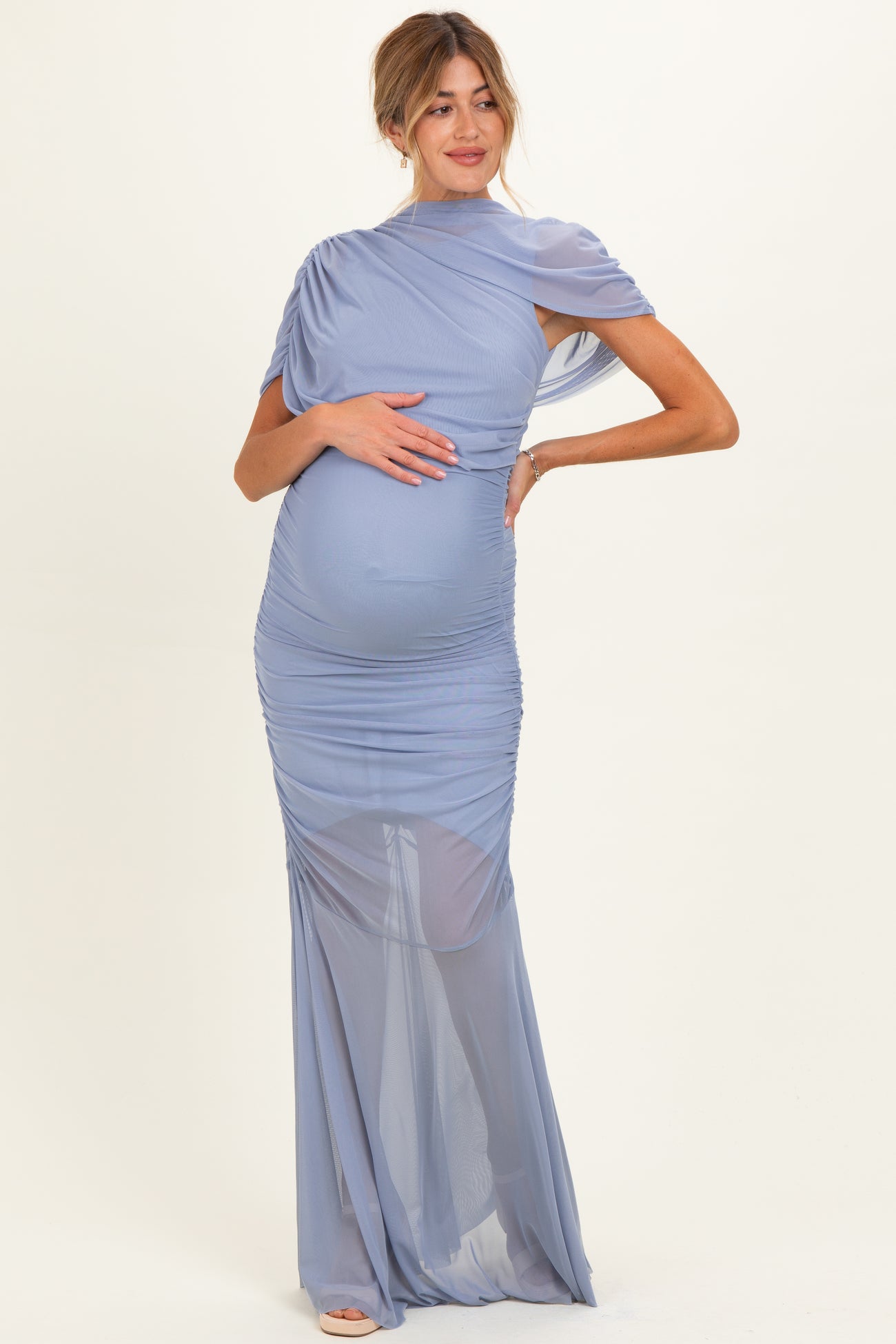 woman wearing a lavender maternity gown with ruched detailing and one shoulder design, highlighting her baby bump