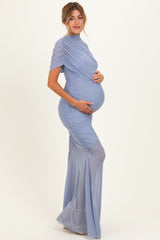 woman wearing a light blue maternity gown with ruched design, showcasing her baby bump