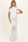woman wearing a white maternity gown with draped details and a sleek fit, highlighting her baby bump