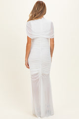 woman wearing a white maternity dress with back ruching and short sleeves, showing off a baby bump