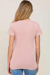 woman wearing a light pink short sleeve maternity top, viewed from the back